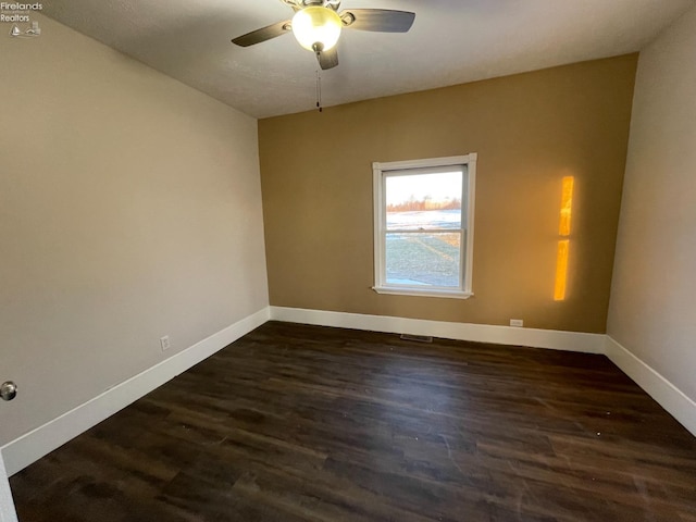 spare room with dark hardwood / wood-style floors and ceiling fan