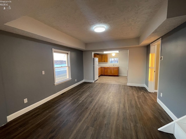 unfurnished living room featuring dark hardwood / wood-style floors and a textured ceiling