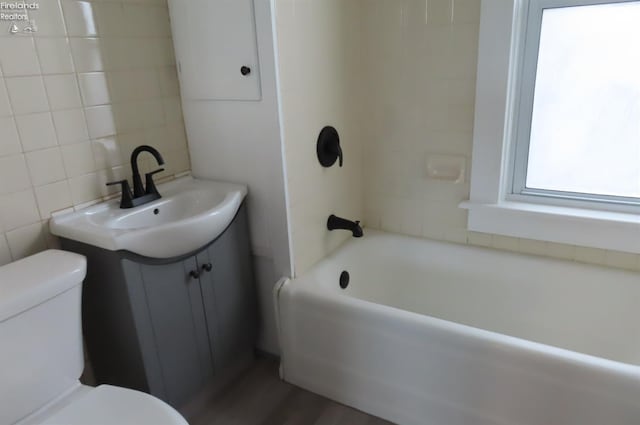 full bathroom with vanity, toilet, shower / bath combination, and tile walls