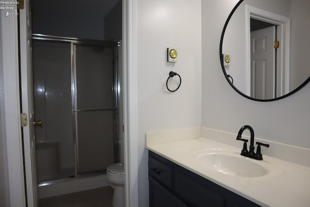 bathroom with an enclosed shower, vanity, and toilet