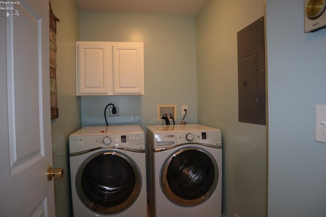 laundry area with cabinets, electric panel, and washer and clothes dryer