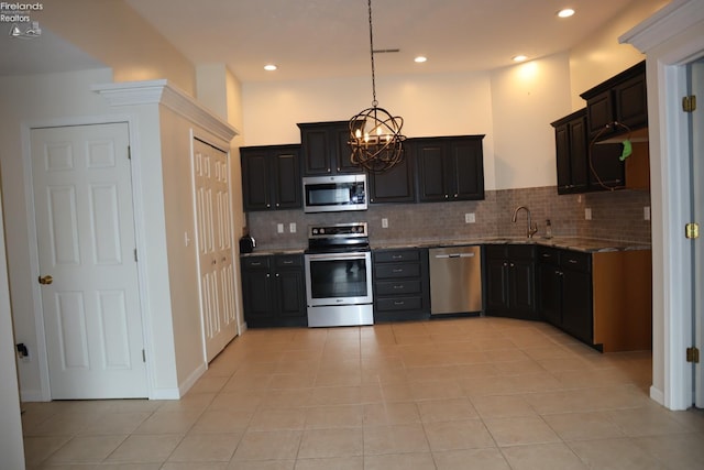 kitchen with light tile patterned flooring, decorative light fixtures, stainless steel appliances, light stone countertops, and decorative backsplash