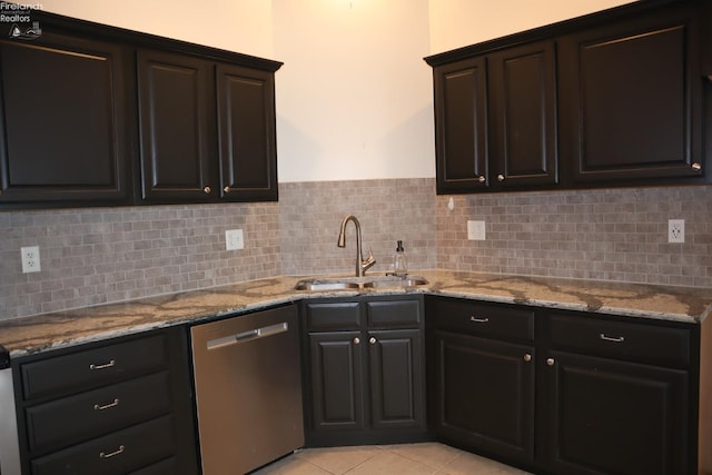 kitchen with sink, light tile patterned floors, backsplash, light stone counters, and stainless steel dishwasher