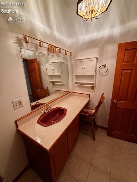 bathroom featuring tile patterned flooring, a notable chandelier, vanity, and a high ceiling