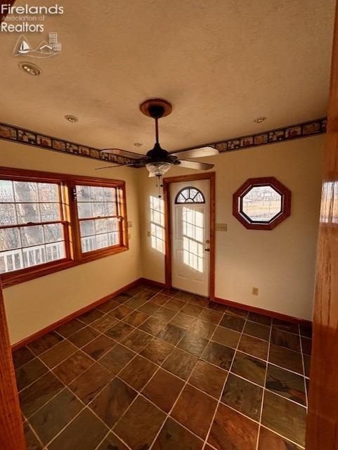 foyer with plenty of natural light, a textured ceiling, and ceiling fan