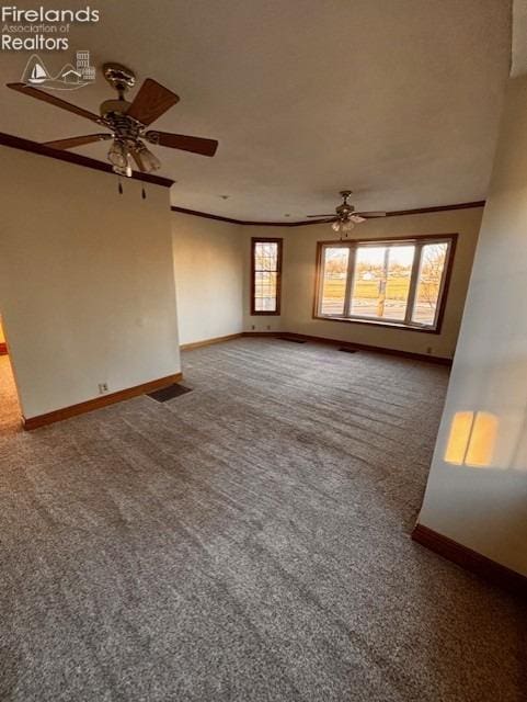 unfurnished living room featuring ornamental molding, ceiling fan, and carpet flooring