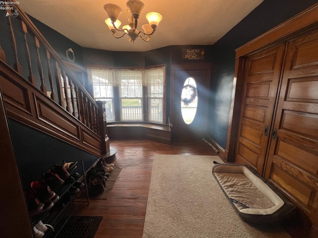 foyer entrance featuring dark wood-type flooring and a notable chandelier