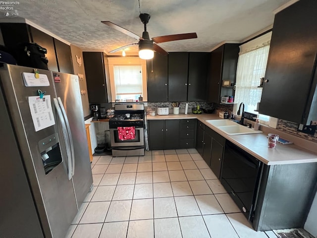 kitchen featuring sink, a textured ceiling, light tile patterned floors, appliances with stainless steel finishes, and decorative backsplash