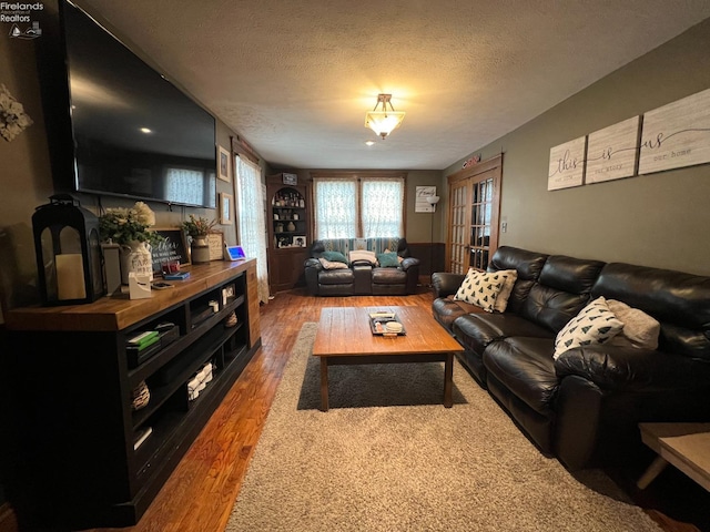 living room with hardwood / wood-style flooring and a textured ceiling