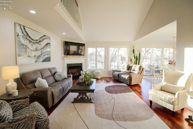 living room with hardwood / wood-style floors, plenty of natural light, and high vaulted ceiling