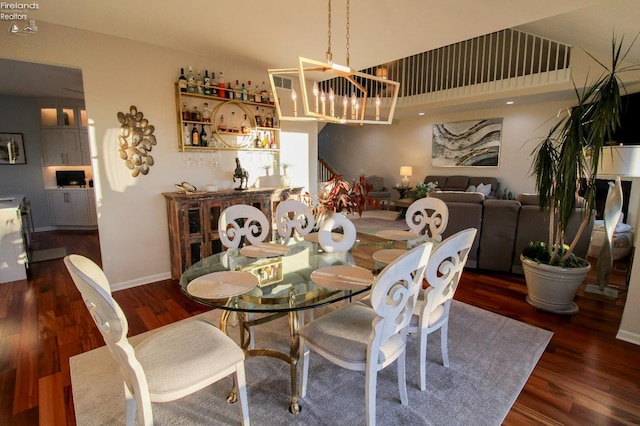 dining area with dark hardwood / wood-style floors and a notable chandelier