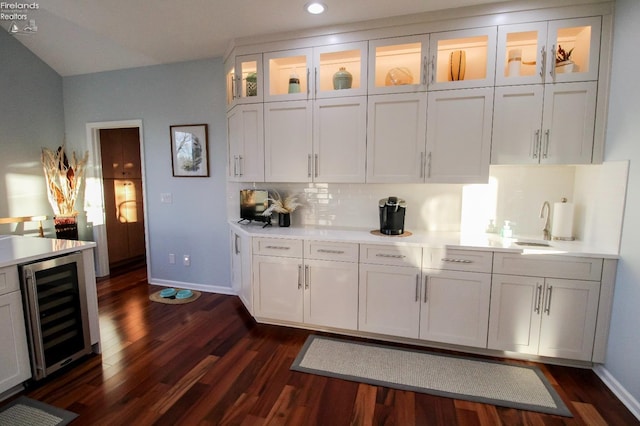 bar featuring sink, white cabinetry, backsplash, wine cooler, and dark hardwood / wood-style flooring