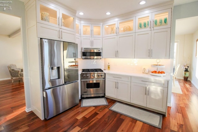 kitchen with white cabinetry, appliances with stainless steel finishes, dark wood-type flooring, and decorative backsplash