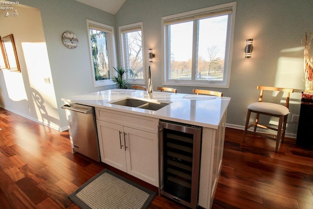 kitchen with white cabinetry, dishwasher, lofted ceiling, sink, and beverage cooler