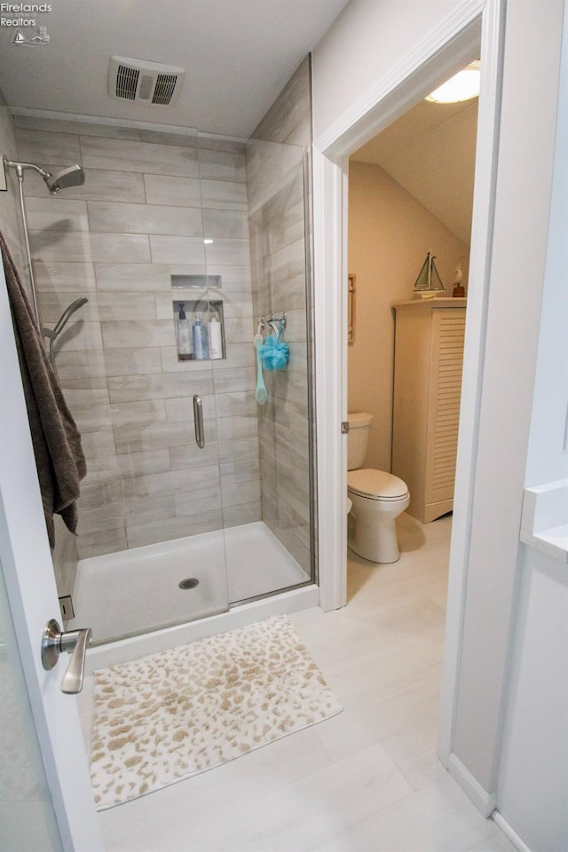 bathroom featuring an enclosed shower and toilet