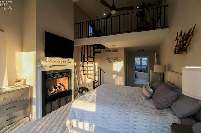 bedroom with a towering ceiling and a fireplace