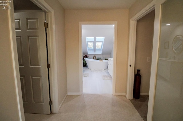 corridor featuring light colored carpet