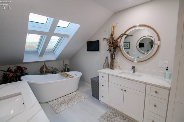 bathroom featuring vanity, lofted ceiling with skylight, and a bathing tub