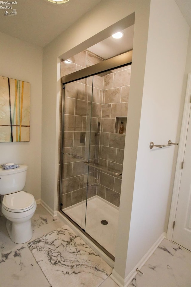 bathroom with a shower with door and toilet