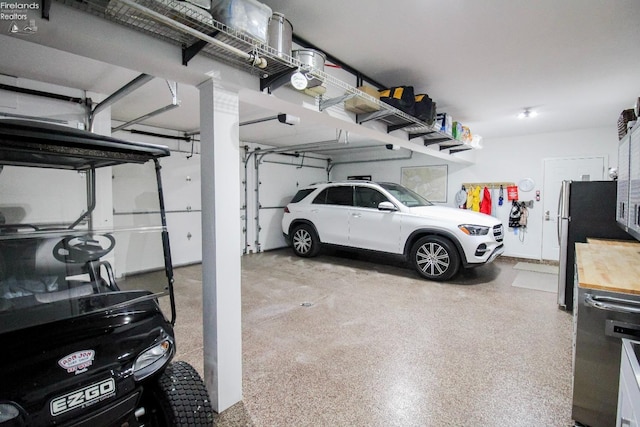 garage featuring a garage door opener and stainless steel fridge