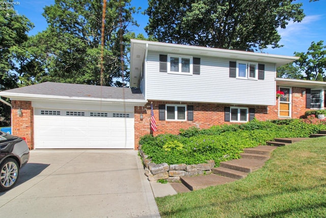 tri-level home featuring a garage and a front yard