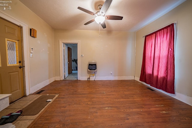 entrance foyer with wood-type flooring, heating unit, ceiling fan, and a textured ceiling