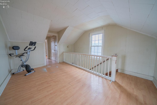 additional living space featuring lofted ceiling and light hardwood / wood-style flooring