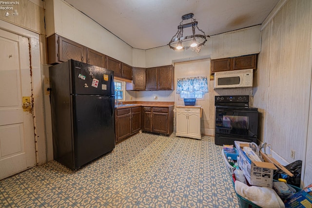 kitchen featuring dark brown cabinetry and black appliances