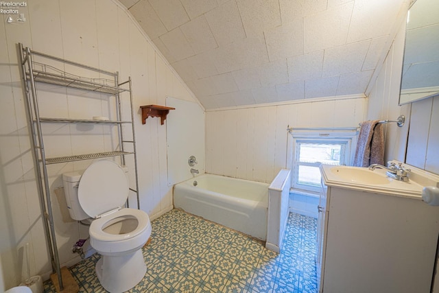 bathroom featuring a bathing tub, wood walls, lofted ceiling, vanity, and toilet