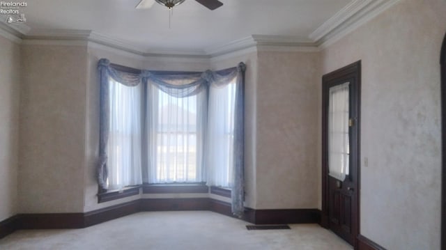 unfurnished room with ornamental molding, carpet floors, and ceiling fan