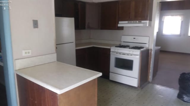 kitchen featuring white appliances and kitchen peninsula