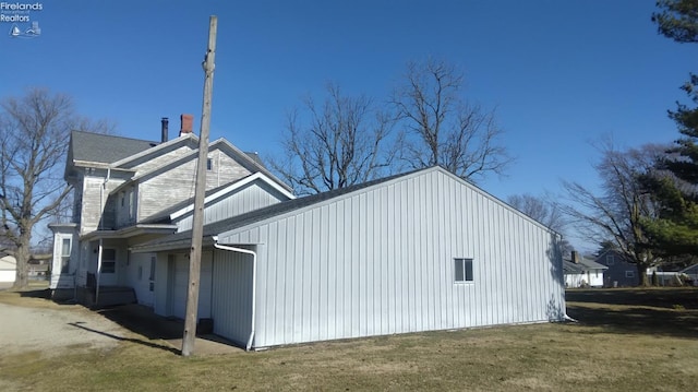 view of property exterior with a garage and a lawn