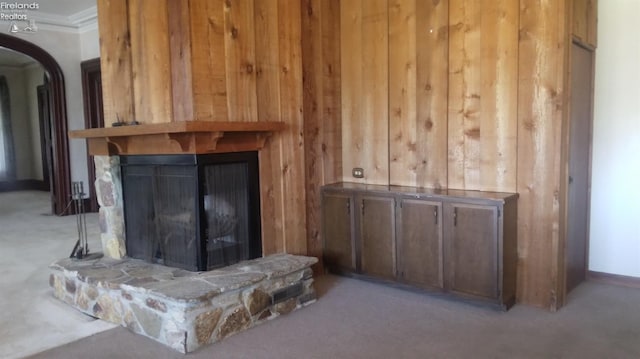 living room with a stone fireplace and wooden walls