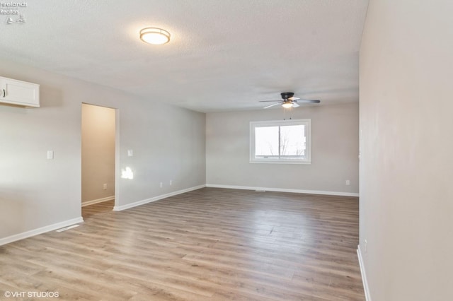 spare room featuring ceiling fan, light hardwood / wood-style flooring, and a textured ceiling