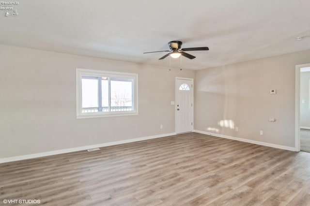 spare room with ceiling fan and light wood-type flooring