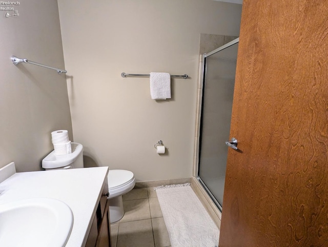 bathroom featuring a shower with door, vanity, tile patterned flooring, and toilet