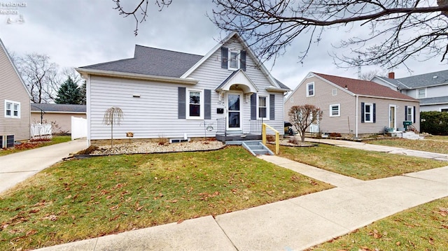 view of front of house with central AC unit and a front lawn