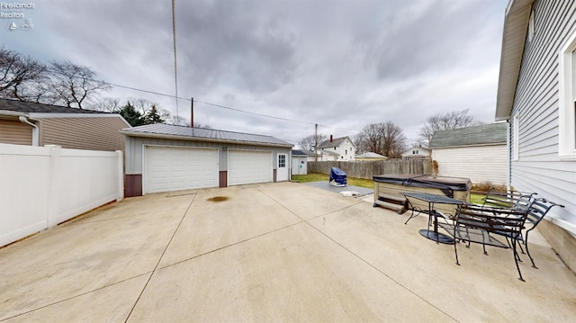 exterior space featuring a garage, a hot tub, and an outdoor structure