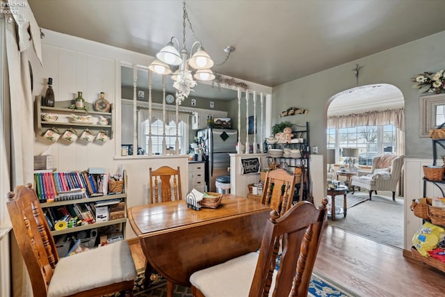 dining area with hardwood / wood-style floors and an inviting chandelier