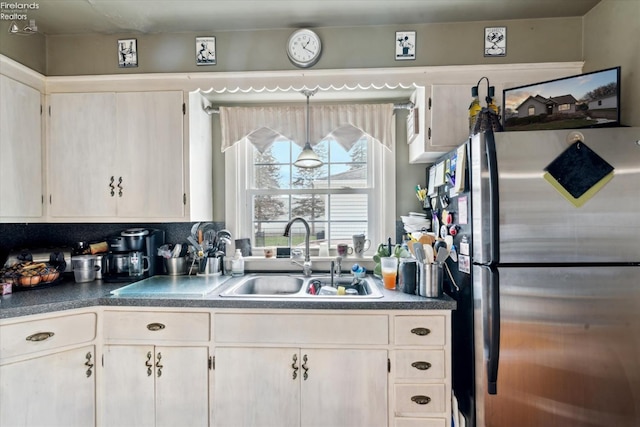 kitchen featuring tasteful backsplash, sink, and stainless steel refrigerator