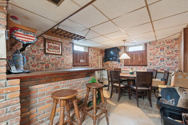 bar with pendant lighting and a drop ceiling