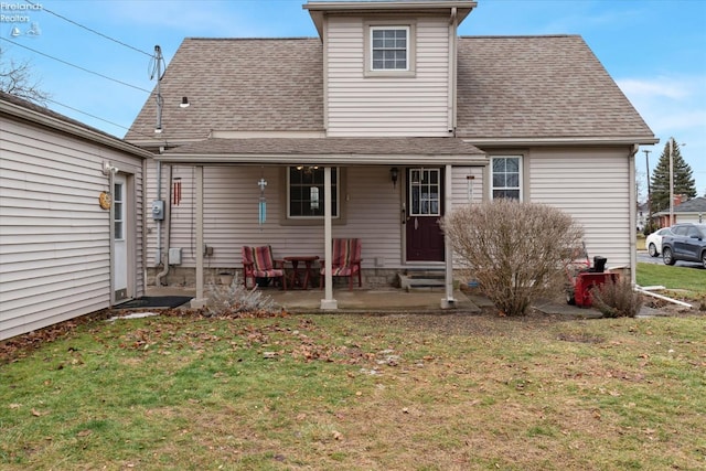 back of house with a patio and a lawn