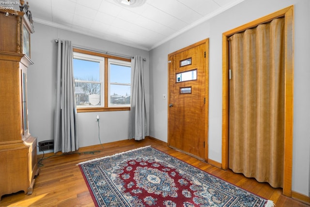 entryway with crown molding and light hardwood / wood-style floors