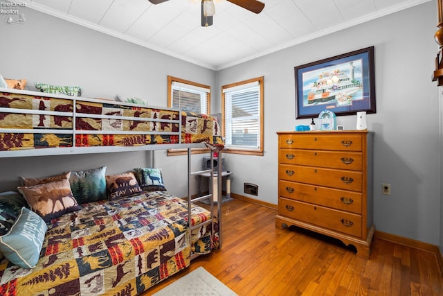 bedroom featuring hardwood / wood-style flooring, crown molding, and ceiling fan