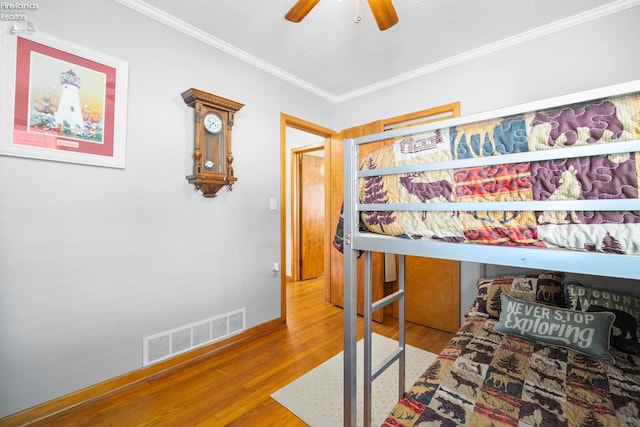 bedroom featuring hardwood / wood-style flooring, crown molding, and ceiling fan