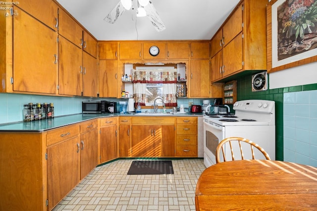 kitchen with white electric range, sink, tile walls, ceiling fan, and backsplash