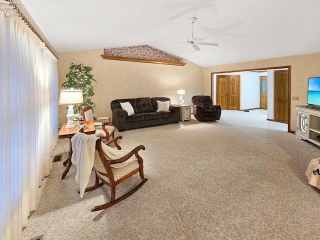 living room with ceiling fan, light colored carpet, and vaulted ceiling