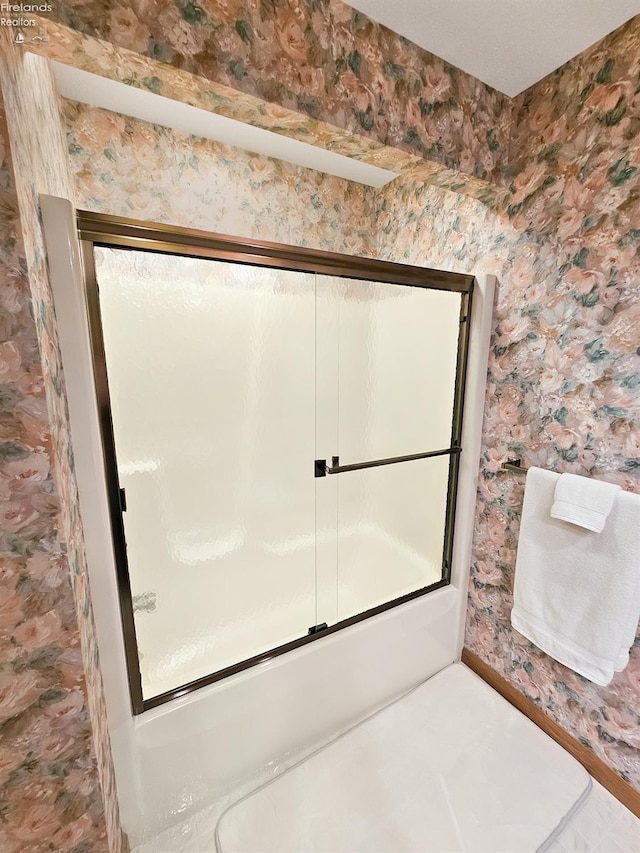 bathroom with combined bath / shower with glass door