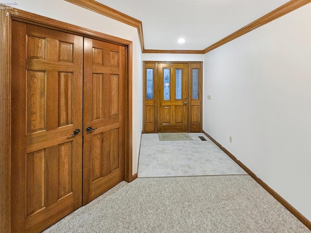 carpeted entryway featuring crown molding