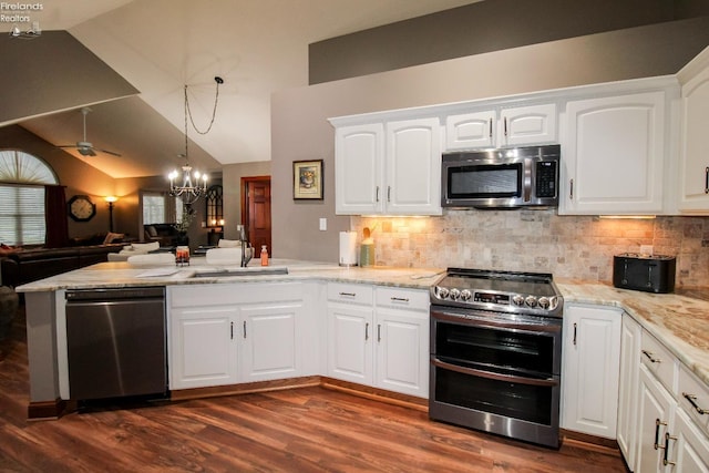 kitchen featuring sink, stainless steel appliances, light stone counters, white cabinets, and decorative light fixtures